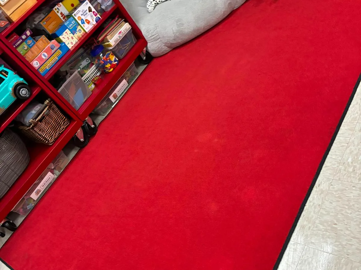 Cleaned classroom with a red rug and shelves in order
